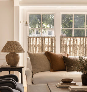 Living room with a white sofa, decorative pillows, and a lamp.